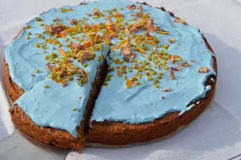Veganer Chai-Karottenkuchen mit Spirulina-Glasur, Pistazien und Rosenblättern, gebacken mit Mangala Sticky Chai Cold Brew