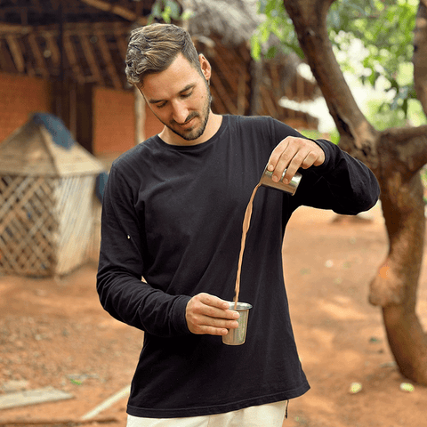 Arian beim traditionellen Chai einschenken in Indien – das authentische Chai-Gießen als Ursprung des Mangala Sticky Chai Rituals